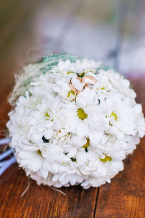 Wedding bouquet of beautiful daisies and ringsの写真素材