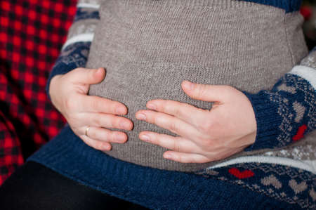 The hands on the abdomen of a pregnant woman