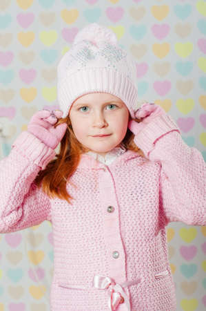 Little girl in a pink hat and a sweaterの写真素材