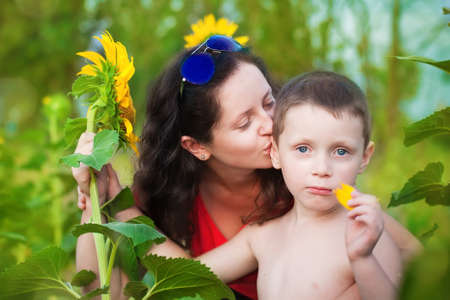 Mother and son in a field of sunflowers in summer smilingの写真素材