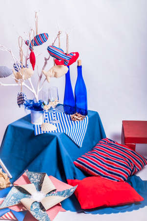 Decoration on the marine theme with seashells, fish, bottles and glassesの写真素材