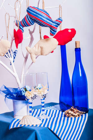 Decoration on the marine theme with seashells, fish, bottles and glassesの写真素材