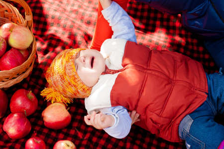 Little boy with apple in autumn parkの写真素材
