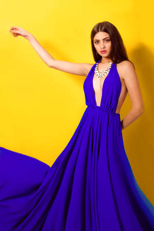 Beautiful young girl with long hair in a long blue dress