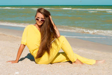 Young beautiful girl with long hair at the beachの写真素材