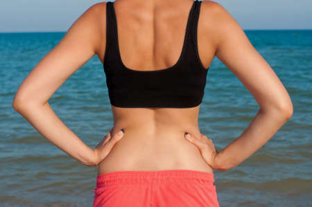 Young beautiful girl athlete on the beach in summerの写真素材