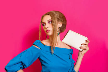 Beautiful girl in fashion dress with handbag clutchの写真素材