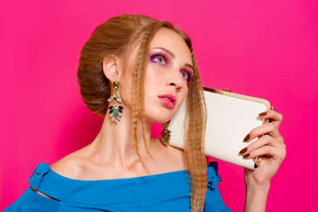 Beautiful girl in fashion dress with handbag clutchの写真素材