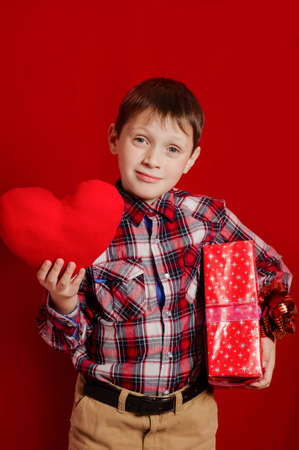 Little boy with a heart of toy and gift box in hands