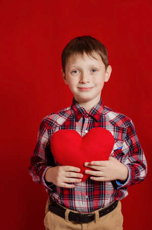Little boy with a heart of toy  in handsの写真素材