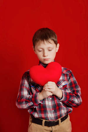 Little boy with a heart of toy in handsの写真素材