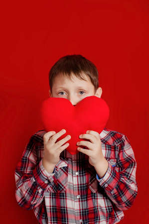 Little boy with a heart of toy  in handsの写真素材