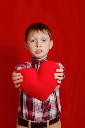 Little boy with a heart of toy  in handsの写真素材