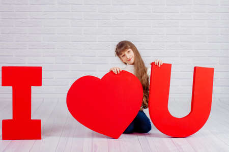 Little girl with a big red word I love youの写真素材