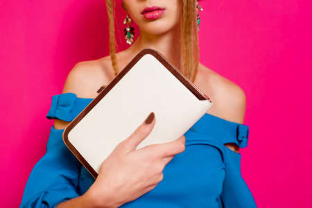 Beautiful girl in fashion dress with handbag clutchの写真素材