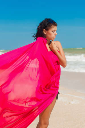 Young girl on the beach in the summer with pink clothの写真素材