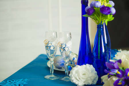 Bridal bouquet of blue iris white tulips glasses and bottles of blueの写真素材