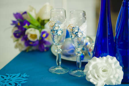 Bridal bouquet of blue iris white tulips glasses and bottles of blueの写真素材