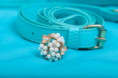 Beautiful ring of pearl and handbag on blue backgroundの写真素材