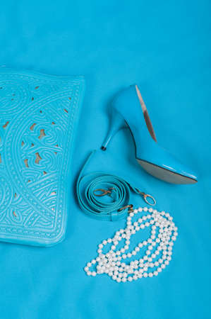 Beautiful blue shoes and handbag, pearls on blue backgroundの写真素材