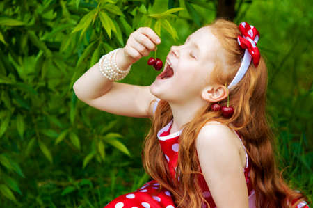 Girl in a beautiful dress in cherry gardenの写真素材