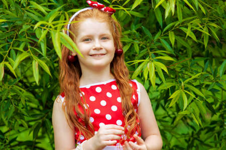 Girl in a beautiful dress in cherry gardenの写真素材