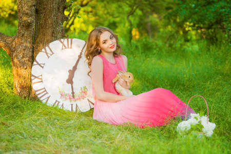 Young beautiful girl in the summer with a rabbitの写真素材