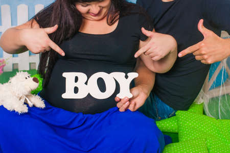 Hands of men and women on pregnant bellyの写真素材