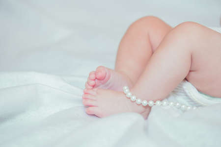 Feet small baby on a white bedの写真素材