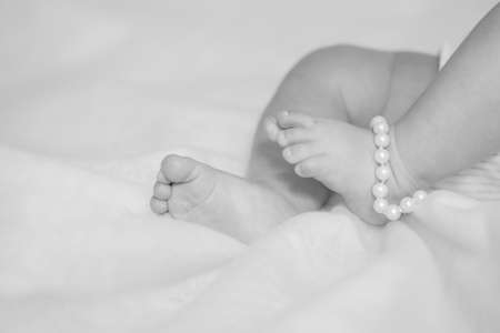 Feet small baby on a white bedの写真素材