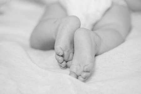 Feet small baby on a white bedの写真素材