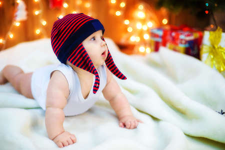 Little baby with gifts at Christmas treeの写真素材