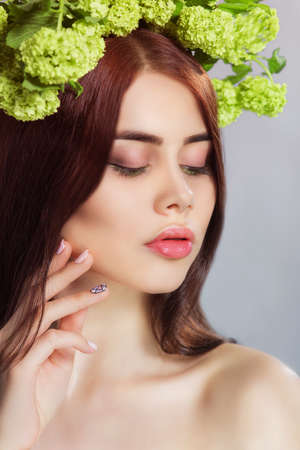 Beauty fashion model Girl with  Flowers Hair Style. Beautiful Model woman with Blooming flowers on her head. Nature Hairstyle. Summer. Holiday Creative Makeup. Make upの写真素材