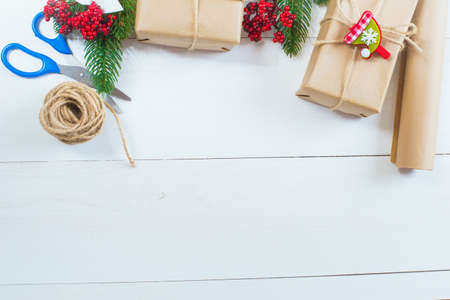 Christmas gift and a sprig of pine needles on a white wooden backgroundの写真素材