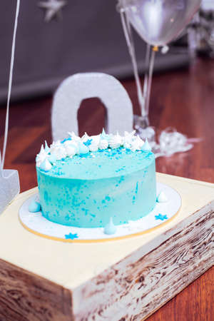 Blue birthday cake with small meringues and white snowflakesの写真素材