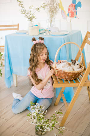 Little cute girl with little bunnies and Easter decor at homeの写真素材