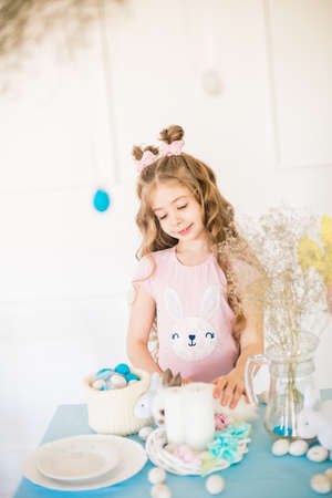 Little cute girl with little bunnies and Easter decor at homeの写真素材