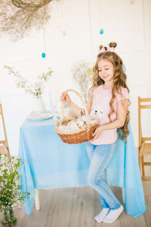 Little cute girl with little bunnies and Easter decor at homeの写真素材