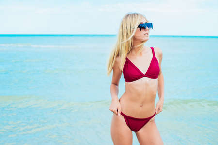 Young woman in red swimsuit relax on beachの写真素材
