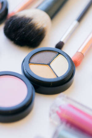 Makeup and makeup brushes on the table. Eye shadow, lipstick, gloss, mascara. Materials and tools for makeup. Beauty and fashionの写真素材