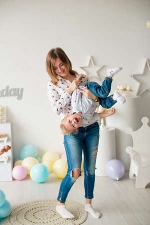 Young mother with her little cute son on his birthday at a children's party with balloons and cakes. Children's party. Balloons. Happy childhoodの写真素材