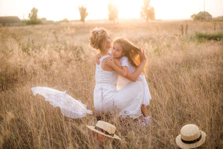 Mother and daughter in wheat field at sunset. Mother's day concept.の写真素材