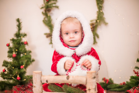 Little cute boy dressed as Santa Claus in a room decorated for Christmas. Christmas and childrenの写真素材