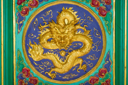 The golden bas relief Chinese dragon on the roof of temple.のeditorial素材