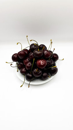 Fresh red cherry fruits on a plate on a white background in close-up. High quality photosの写真素材