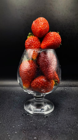 Strawberry fruit creating a beautiful splash with black backgroundの写真素材