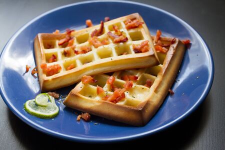 Belgium waffle with a slice of lime an a blue plateの写真素材