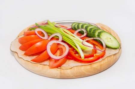 A set of vegetables on a plate on white background. Tomato, cucumber, onion, pepper.の写真素材