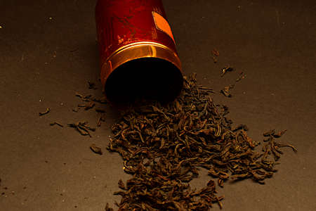 Sprinkle a bunch of dried tea leaves from a metal can.の写真素材