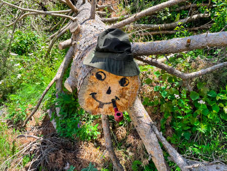 A doll with a smile made of wood in a hat and with a smoking pipeの写真素材
